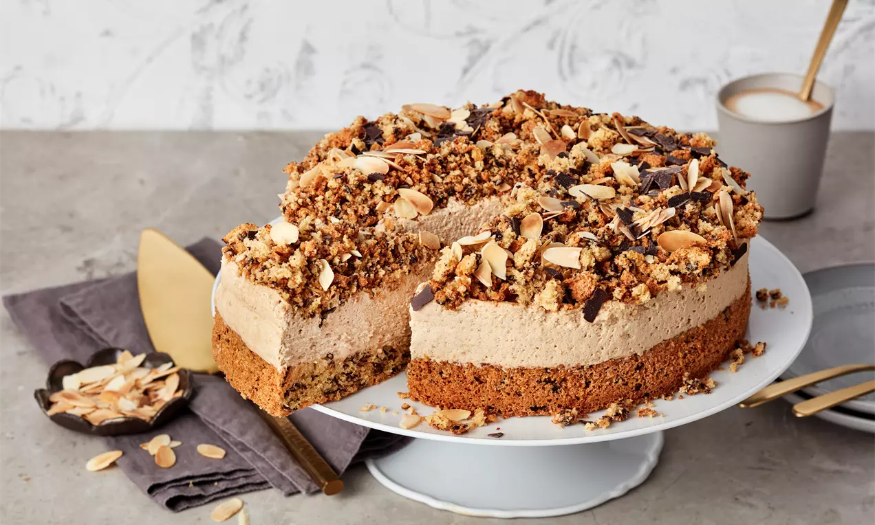 Eiskaffee-Torte mit cremiger brauner Kaffee-Füllung auf knusprigem Boden, bedeckt von knusprigen Mandel-Blättchen und Schokostückchen